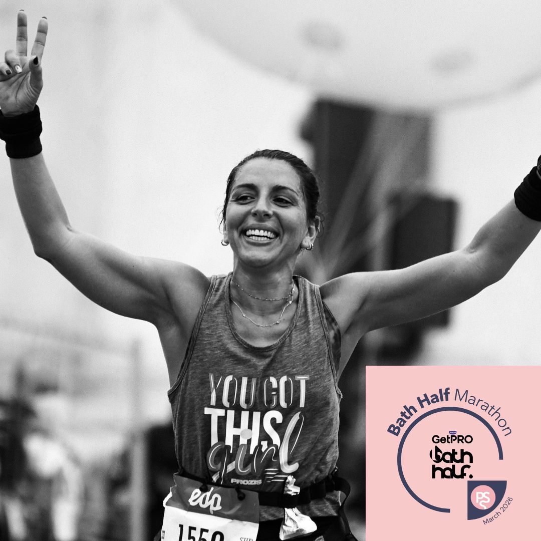 Bath Half Website Image (1) Woman holding her fundraising shirt smiling